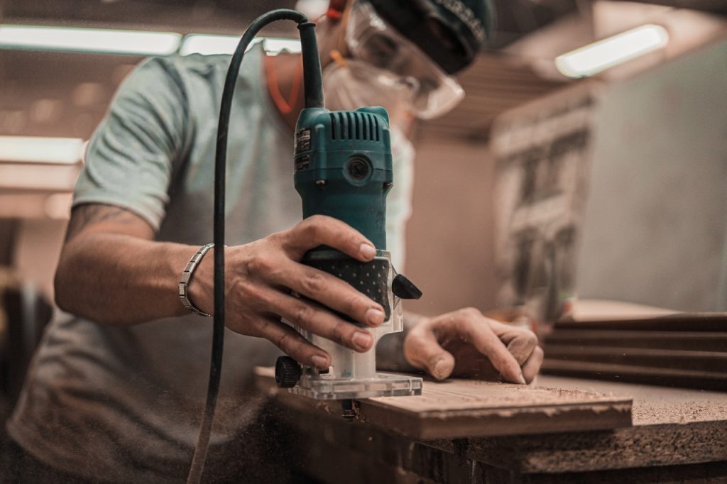 homme qui coupe une planche de bois